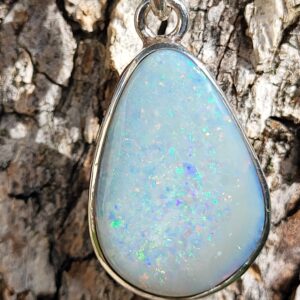 Pendentif en Opale Australienne, sur argent 925. Opale blanche aux iridescences arc-en-ciel multicouleur. De forme type poire ou goutte, avec une bélière en breloque.