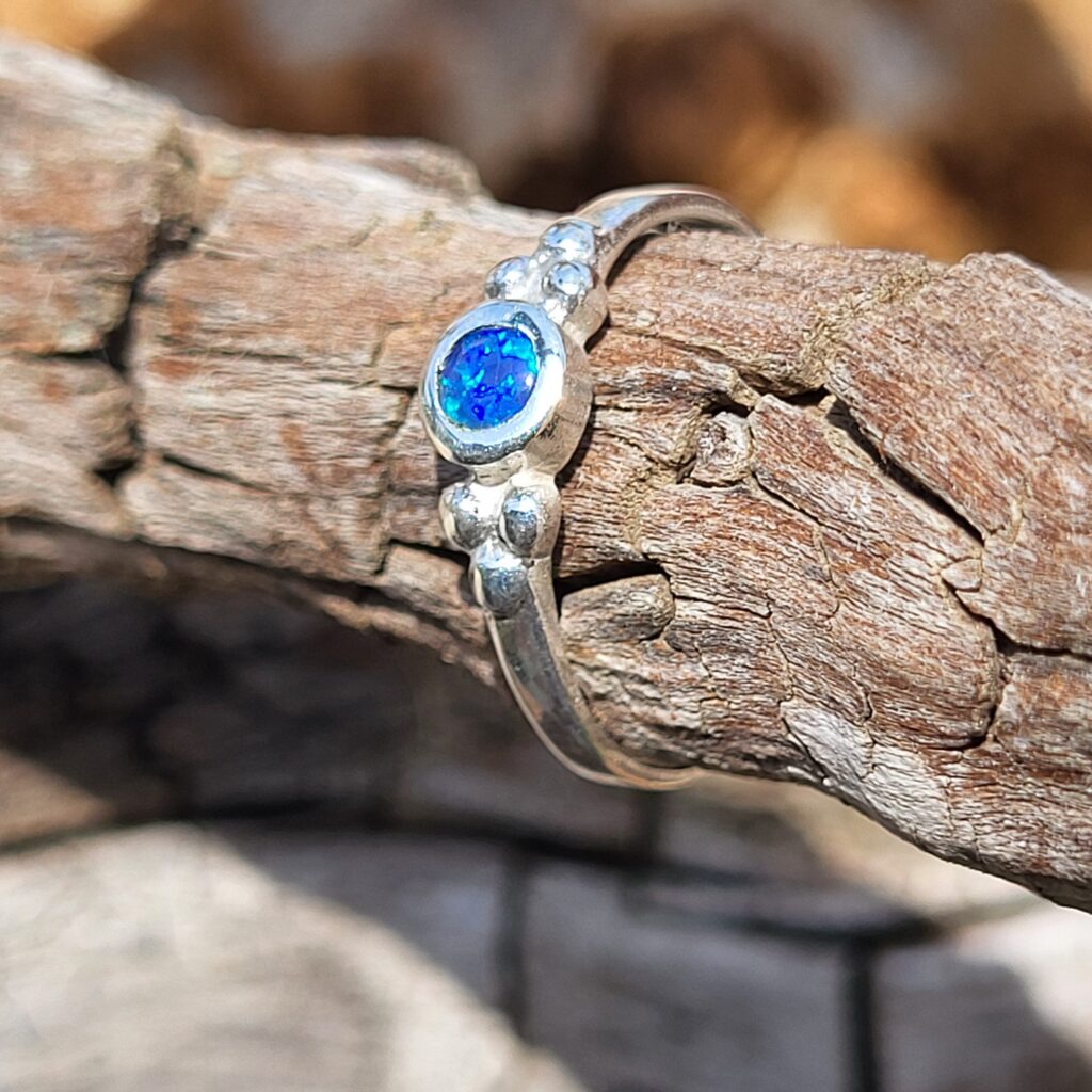 Bague avec une opale australienne bleu ronde sur de l'argent 925